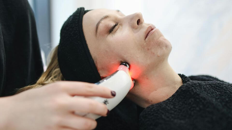 A person getting a red light therapy face treatment.